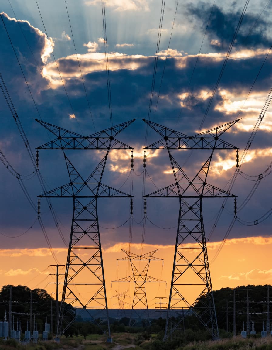 Power transmission towers and grid infrastructure at sunset